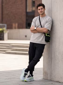 Gelnimbus 28 Extra Wide – An urban streetwear look consisting of cropped black cargo pants, an oversized light grey boxy tee, and a neon green crossbody bag.