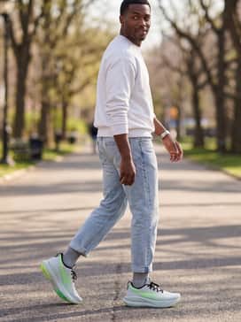 Gelnimbus 28 Extra Wide – A casual weekend ensemble with light-wash tapered denim, a crisp white crewneck sweatshirt, and low-cut grey athletic socks.