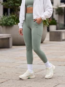 Gelnunobiki – Sage green high-waisted leggings and a matching sports bra topped with a white oversized cropped hoodie for a cohesive gym-to-brunch outfit.