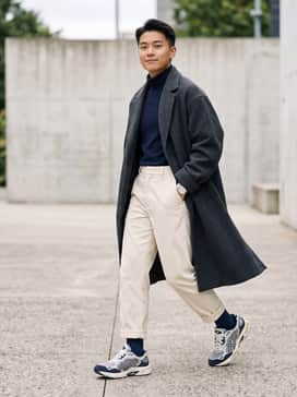 Gelnyc 20 – A pair of wide-leg cream corduroy trousers paired with a tucked-in navy turtleneck and an oversized charcoal overcoat for a sophisticated streetwear look.