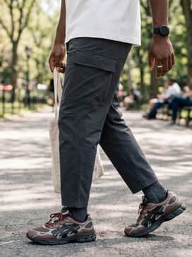 Straight-leg dark indigo denim with a tucked-in white heavyweight t-shirt and a navy blue puffer vest for a balanced weekend look.