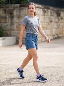 Gelpulse 17 – Mid-wash denim shorts and a heather grey graphic tee for a relaxed, sporty summer look that emphasizes comfort for all-day walking.