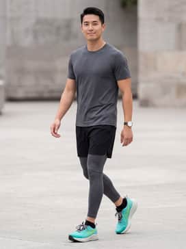 Athletic Performance: Charcoal grey compression tights under black running shorts, paired with a fitted teal moisture-wicking performance tee to match the shoes.