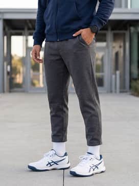 A modern athleisure ensemble consisting of charcoal grey tapered joggers, a fitted navy blue zip-up hoodie, and a sleek sports watch for a coordinated gym-to-street transition.