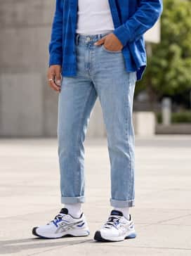 Gelsd Lyte – Straight-leg light-wash denim jeans with a white ribbed tank top and an unbuttoned electric blue flannel shirt for a coordinated casual weekend look.