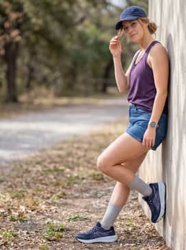 Gelsonoma 8 – Classic medium-wash denim shorts with a relaxed-fit purple racerback tank top and a matching navy baseball cap.