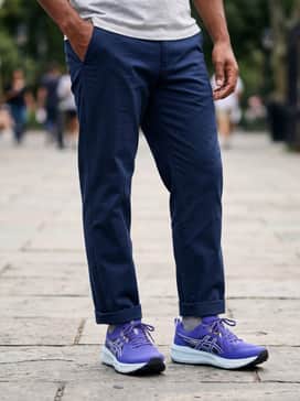 A refined athletic look consisting of tapered navy blue joggers, a crisp white performance t-shirt, and a lightweight violet-accented zip-up hoodie for a coordinated, sporty aesthetic.