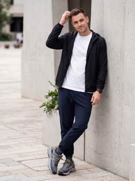 Gelventure 11 Extra Wide – Style with dark navy joggers, a crisp white oversized graphic t-shirt, and a black lightweight windbreaker for a modern, athletic-inspired streetwear ensemble.