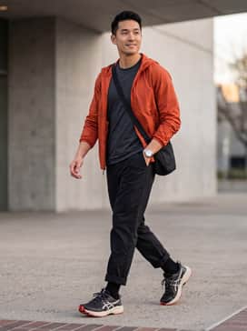 A pair of black technical ripstop cargo pants, a moisture-wicking charcoal grey t-shirt, and a lightweight orange windbreaker to echo the outsole color.