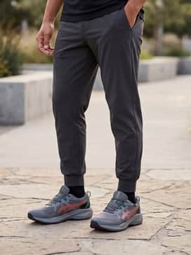 Gelventure 11 Waterproof – A rugged gorpcore outfit with olive green ripstop cargo pants, a black waterproof hardshell jacket, and a matching teal beanie to highlight the shoe's accent colors.