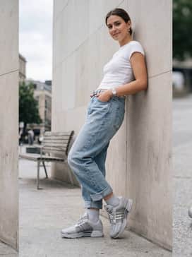 Go for an edgy urban vibe with baggy light-wash distressed jeans, a silver chain belt, and a white graphic baby tee that mirrors the metallic sheen of the shoes.