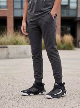 Casual school attire consisting of slim-fit dark denim jeans, a vibrant graphic t-shirt, and a lightweight zip-up windbreaker.