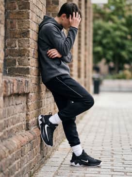 An athletic leisure look pairing tapered charcoal grey joggers with a moisture-wicking tech-fleece hoodie in a bold primary color like red or blue.