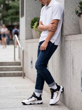 Dark wash slim-fit jeans paired with a white performance polo for a clean, casual school outfit.