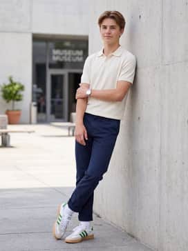 Navy blue chinos cuffed at the ankle, worn with white crew socks and a tucked-in cream-colored polo shirt for a smart-casual retro vibe.