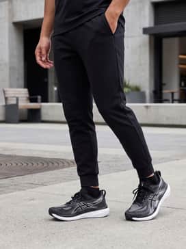 A clean athleisure ensemble consisting of tapered black joggers, a crisp white oversized heavy-cotton t-shirt, and a structured black baseball cap for a modern street-ready vibe.