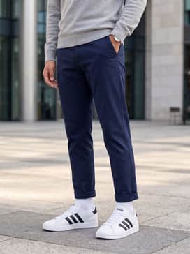 Navy blue tapered chinos combined with a light grey cashmere sweater for a sophisticated yet relaxed office-appropriate outfit.