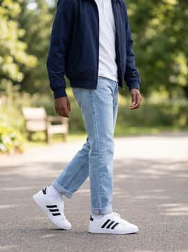 Light-wash straight-leg jeans with a tucked-in white polo shirt and a navy Harrington jacket for a classic retro-sporty vibe.