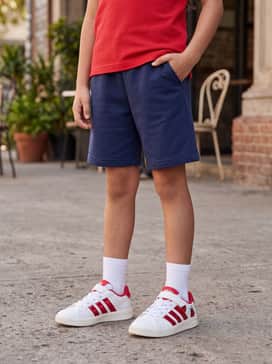 Navy blue jersey shorts paired with a bright red graphic polo for a coordinated, sporty aesthetic.
