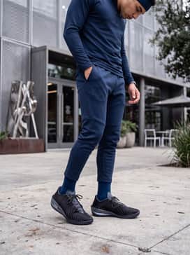 A modern athletic look consisting of obsidian-blue tapered tech fleece joggers, a fitted dry-fit quarter-zip training top, and a matching performance headband for a streamlined appearance.
