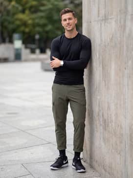 Style with olive green technical cargo pants and a fitted black long-sleeve performance top for a functional and sharp urban streetwear look.