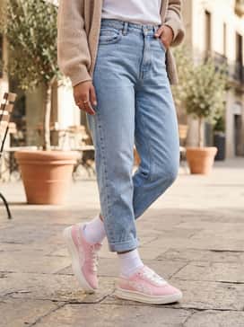 Gv Special Bloom Womens Sneakers – Light-wash high-waisted mom jeans, a tucked-in white graphic tee with pink lettering, and an oversized beige cardigan for a cozy, tonal weekend look.