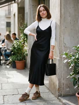 A black satin midi-length slip dress layered over a slim-fit white turtleneck to lean into a nostalgic 90s-meets-modern aesthetic.