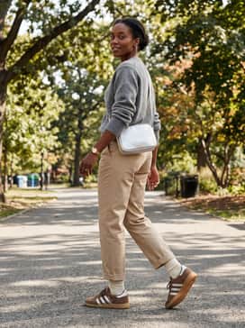 Handball Spezial Lo Pro Shoes – Beige tailored trousers and a grey chunky knit cashmere sweater, accessorized with a silver crossbody bag to highlight the shoe's metallic stripes.