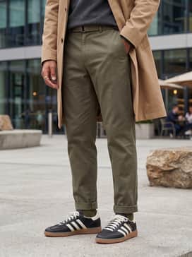Handball Spezial Mig Shoes – Olive green tapered chinos worn with a charcoal gray cashmere sweater and a tan trench coat for a sophisticated smart-casual ensemble.