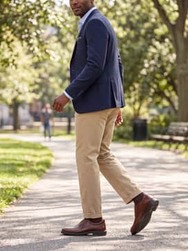Helsinki 2 – Classic khaki chinos paired with a navy blazer and a subtle patterned pocket square to create a refined preppy aesthetic suitable for dinner or events.
