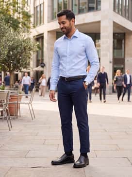 Helsinki 2 – Navy blue chinos worn with a light blue button-down oxford shirt, tucked in to highlight a matching black leather belt.