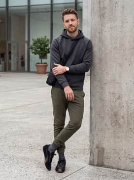 Slim-fit joggers in olive green topped with a tech-fleece hoodie and a minimalist nylon crossbody bag for an athletic-inspired ensemble.