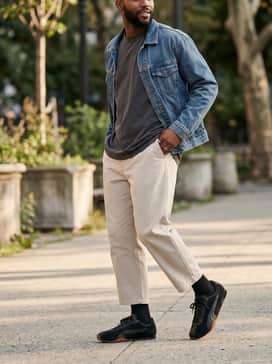 Hstreet Premium – High-waisted cropped trousers in a neutral stone color with a tucked-in oversized graphic tee and a denim jacket for a relaxed weekend vibe.
