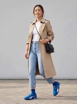 Hstreet Track  Field – Light-wash cropped straight-leg jeans paired with a tucked-in white ribbed baby tee and an oversized beige trench coat for a modern city look.