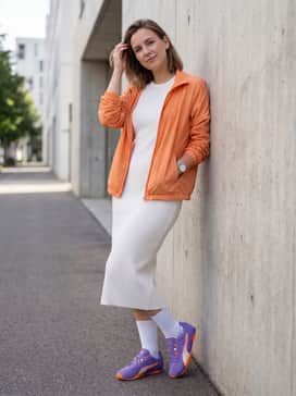 Hstreet Track  Field Womens Sneakers – A white rib-knit midi dress layered under a lightweight orange windbreaker to create a playful, high-contrast feminine sporty outfit.