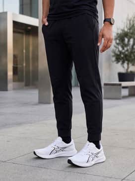 Hyper Speed 5 – A modern street style ensemble consisting of tapered black joggers, a crisp white oversized hoodie, and a matte black puffer vest for cooler outdoor workouts or errands.