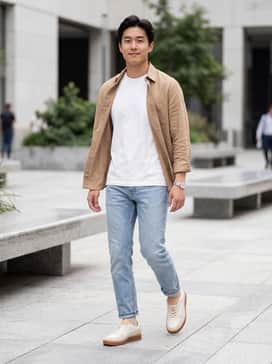 Straight-leg light-wash denim paired with a crisp white heavyweight organic cotton t-shirt and an unbuttoned tan linen overshirt for a layered, tonal look.
