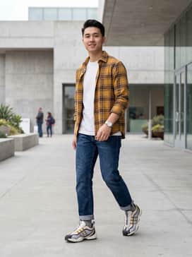 Straight-leg raw denim jeans cuffed at the ankle, paired with a heavyweight white graphic tee and an unbuttoned mustard yellow flannel shirt to echo the shoe's accents.