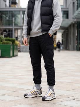 Black tapered nylon cargo pants, a heather grey oversized hoodie, and a matte black puffer vest for a tech-inspired urban look that emphasizes the chunky silhouette.