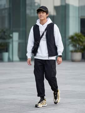 Intimidation Shoes – Baggy black cargo pants paired with a crisp white oversized graphic hoodie and a yellow-trimmed baseball cap for a complete streetwear look.