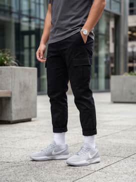 Ja 2 – Baggy black cargo trousers styled with a tucked-in vintage graphic tee in shades of grey and an open navy blue flannel shirt for a relaxed, layered urban aesthetic.