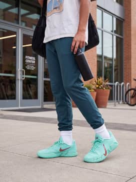 Ja 3 12 Time – Tapered black tech-fleece joggers, a crisp white oversized graphic t-shirt, and a teal snapback cap to tie the look together.