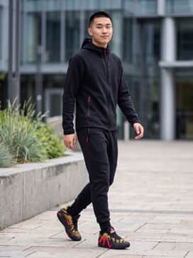 A full black tech-fleece tracksuit with subtle red zipper details to perfectly complement the shoe's vibrant accents.
