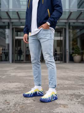 Ja 3 Murray State – Streetwear aesthetic with light-wash slim-fit jeans, an oversized white graphic tee, and a navy blue windbreaker with yellow detailing.