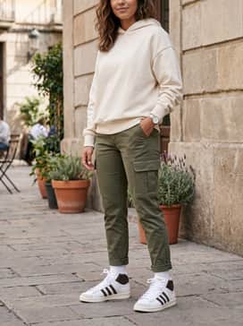 Style with olive green cargo pants and an oversized cream-colored hoodie for a modern streetwear aesthetic that plays with earthy tones.
