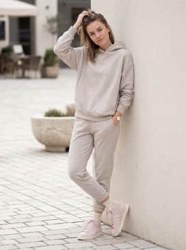 Neutral-toned joggers and a matching oversized hoodie for a clean, cohesive athleisure ensemble perfect for travel or errands.