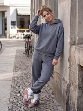 Slate grey oversized joggers and a matching cropped hoodie accessorized with silver jewelry for a contemporary athletic-luxe vibe.