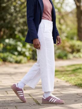 Jabbar Lo W Shoes – Crisp white wide-leg trousers with a tonal dusty rose tee and a navy blue structured blazer for a refined smart-casual look.