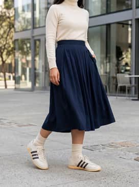 Japan Decon Shoes – A navy blue silk midi slip dress layered over a slim-fitting white turtleneck, accessorized with delicate gold hoop earrings to complement the shoe's metallic branding.