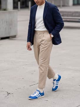 Style them with beige pleated trousers, a white mock-neck long-sleeve top, and a dark blue blazer to bridge the gap between sportswear and smart-casual.